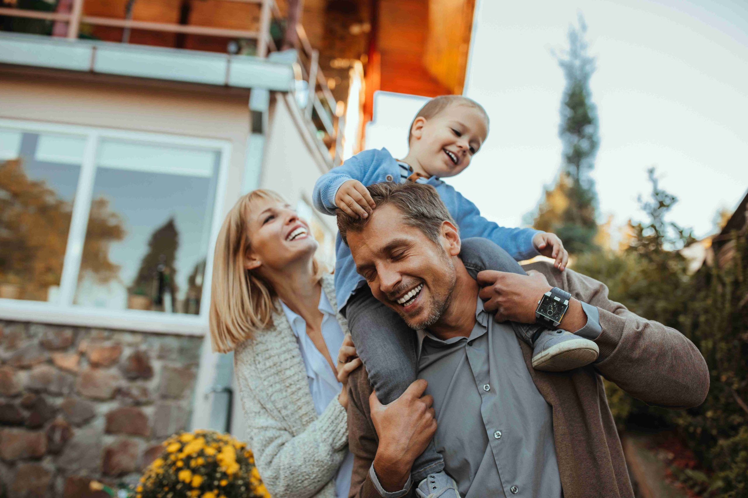 Famille heureuse devant sa maison